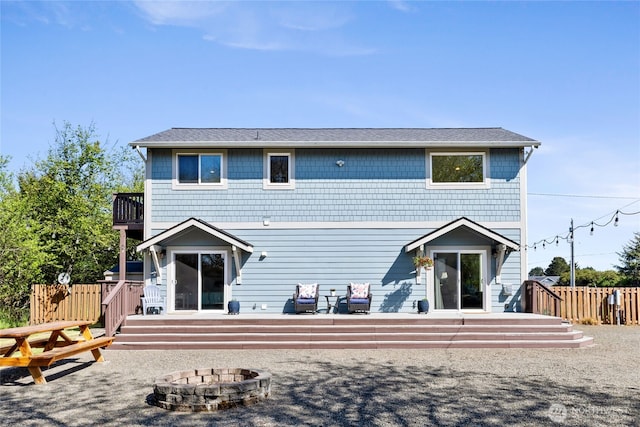 back of house featuring an outdoor fire pit, fence, a wooden deck, and roof with shingles