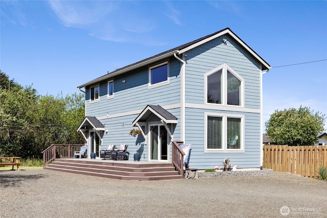 traditional-style house featuring a wooden deck and fence
