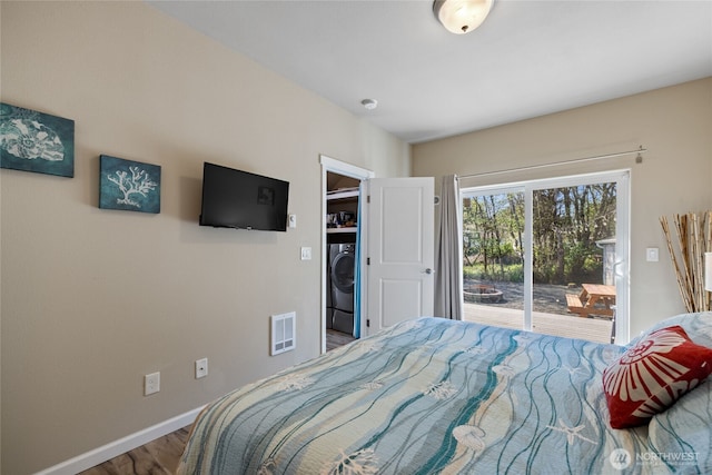 bedroom with washer / dryer, access to exterior, wood finished floors, and baseboards
