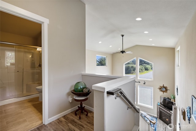 hallway featuring an upstairs landing, wood finished floors, vaulted ceiling, baseboards, and recessed lighting