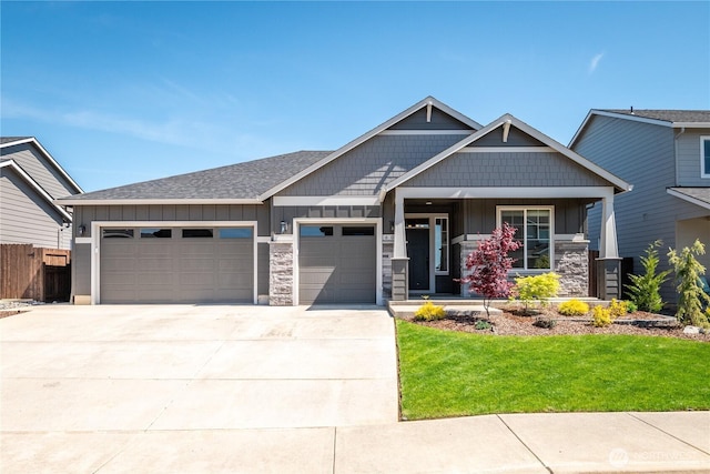 craftsman-style home featuring board and batten siding, an attached garage, a front yard, and driveway