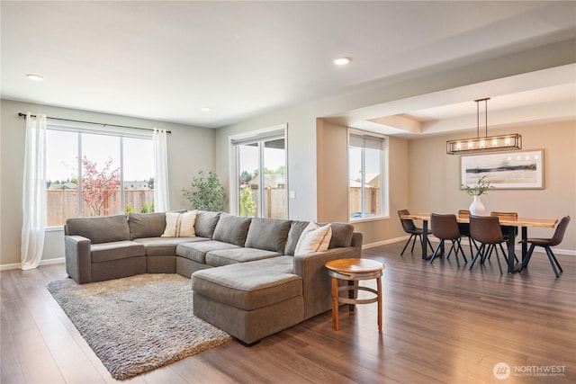 living area with wood finished floors, baseboards, and recessed lighting