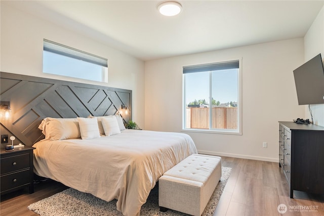 bedroom with light wood-type flooring and baseboards