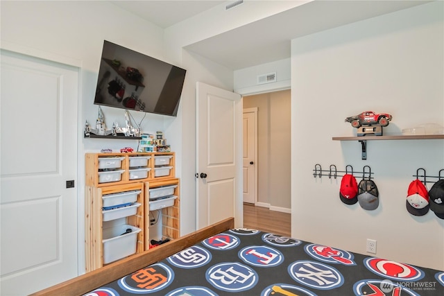 bedroom with a bar and wood finished floors
