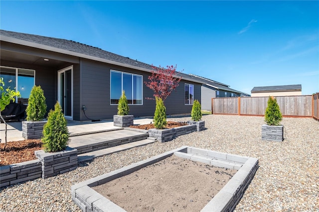back of property featuring a patio area, uncovered parking, and a garden