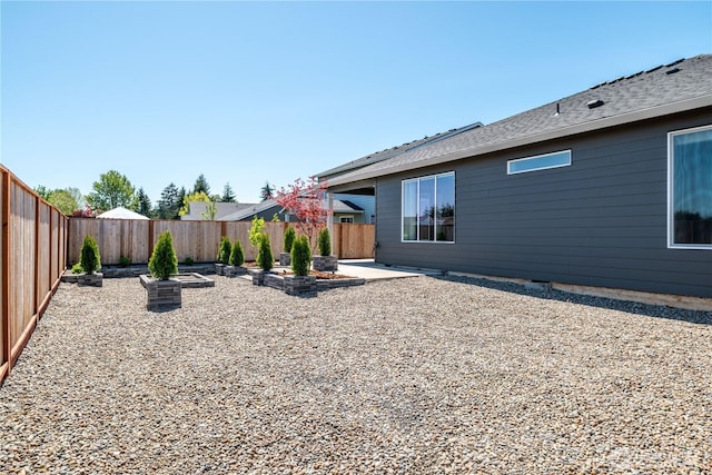 rear view of house with a fenced backyard and a patio area
