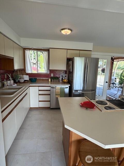 39418 200th Ave SE, Auburn, WA 98092 - kitchen with stainless steel appliances, a sink, backsplash, light countertops, and white cabinetry