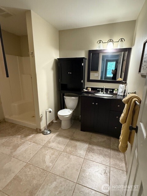 39418 200th Ave SE, Auburn, WA 98092 - full bathroom featuring vanity, toilet, walk in shower, tile patterned floors, and baseboards