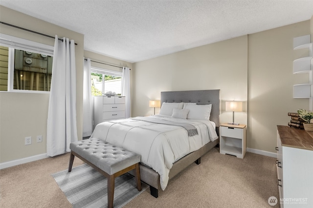 bedroom featuring light colored carpet, baseboards, and a textured ceiling