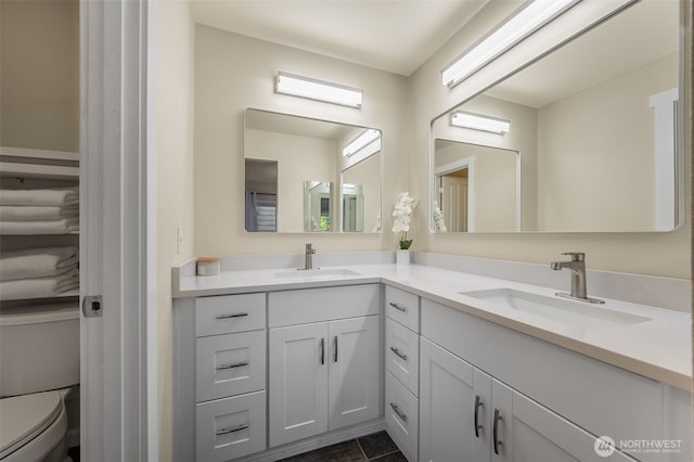 bathroom featuring double vanity and toilet