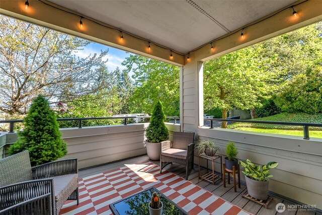 balcony featuring view of wooded area