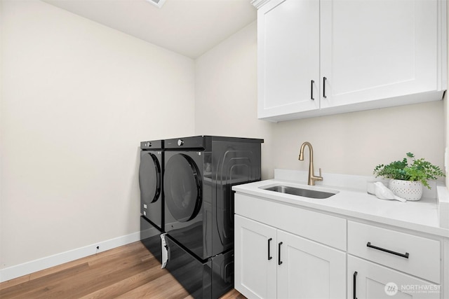 5411 Lonicera Dr, Blaine, WA 98230 - laundry area featuring washing machine and dryer, cabinet space, light wood-type flooring, and baseboards