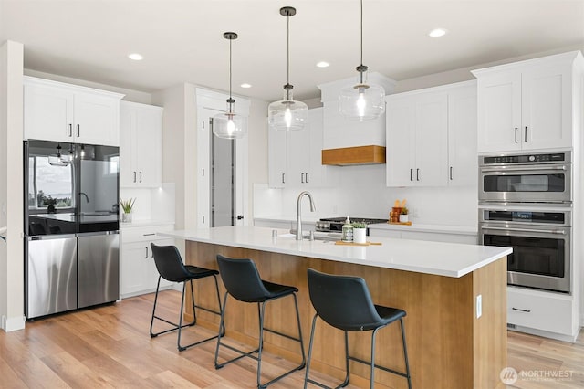 5411 Lonicera Dr, Blaine, WA 98230 - kitchen with stainless steel appliances, light wood-style flooring, a sink, white cabinets, and recessed lighting