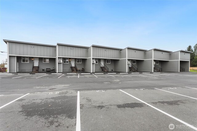 view of property featuring entry steps and uncovered parking