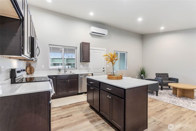 kitchen featuring stainless steel appliances, light wood finished floors, dark brown cabinetry, recessed lighting, and light countertops