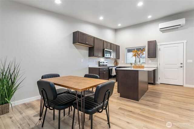 dining space with an AC wall unit, light wood finished floors, recessed lighting, baseboards, and a towering ceiling