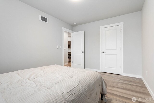bedroom with light wood finished floors and baseboards