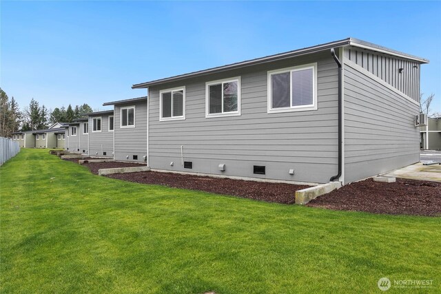 back of house with a yard, crawl space, and board and batten siding