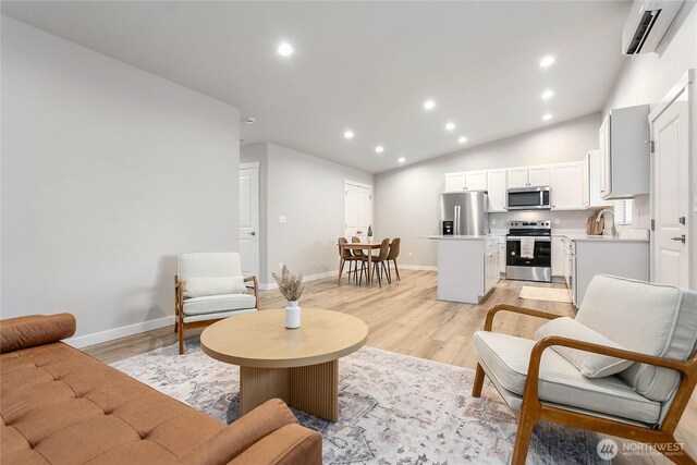 living room with a wall unit AC, light wood-type flooring, recessed lighting, baseboards, and lofted ceiling