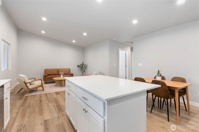 kitchen with a kitchen island, recessed lighting, light wood-type flooring, white cabinets, and light countertops