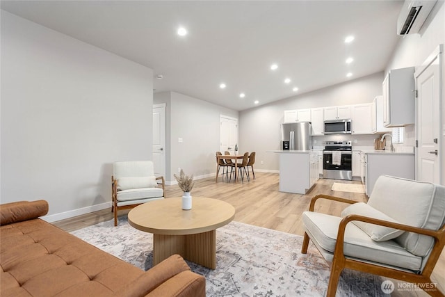 living room with a wall mounted AC, light wood finished floors, recessed lighting, vaulted ceiling, and baseboards
