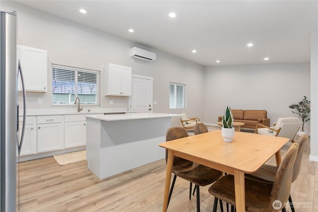 dining area with a wall mounted air conditioner, recessed lighting, and light wood-style floors