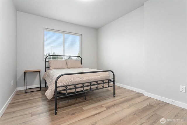 bedroom featuring light wood-style floors and baseboards