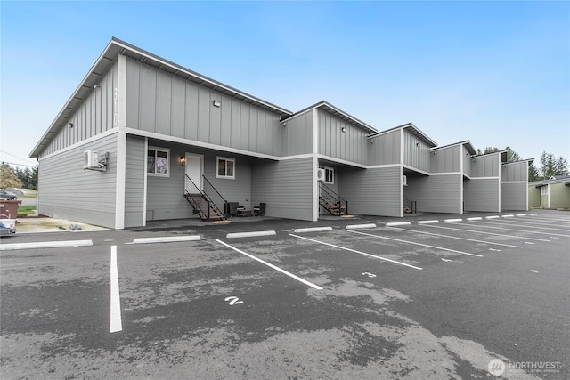 view of building exterior featuring entry steps and uncovered parking