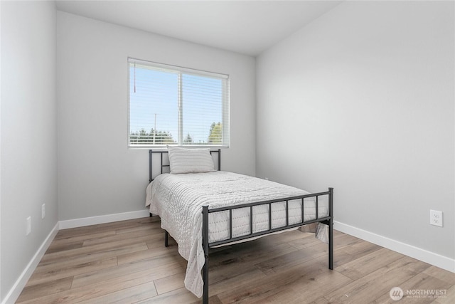 bedroom featuring wood finished floors and baseboards