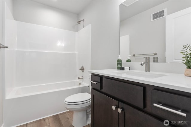 bathroom with wood finished floors, toilet, shower / bath combination, and vanity