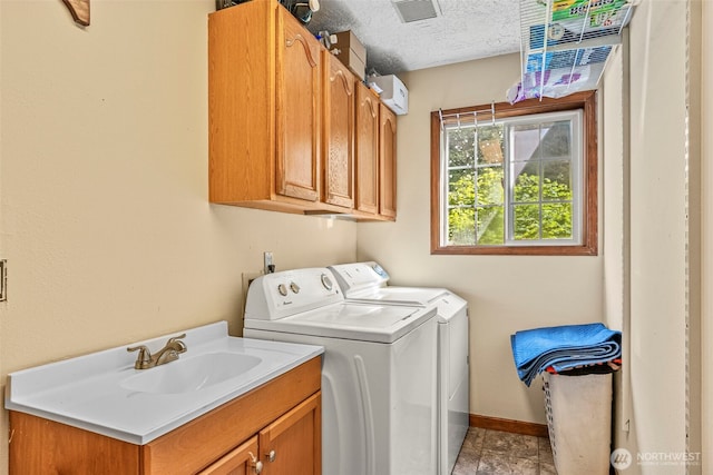 161 Mill Creek Rd, Longview, WA 98632 - laundry room featuring washing machine and clothes dryer, cabinet space, baseboards, and a textured ceiling