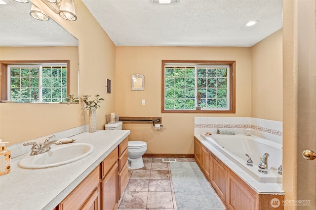 161 Mill Creek Rd, Longview, WA 98632 - bathroom featuring a textured ceiling, healthy amount of natural light, baseboards, a tub with jets, and vanity