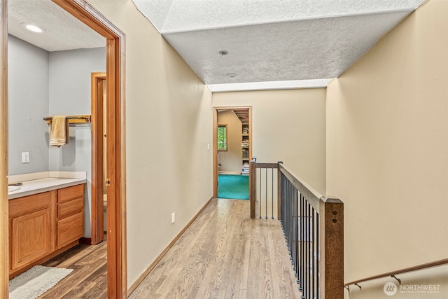 161 Mill Creek Rd, Longview, WA 98632 - hall with an upstairs landing, light wood-style flooring, a textured ceiling, and baseboards