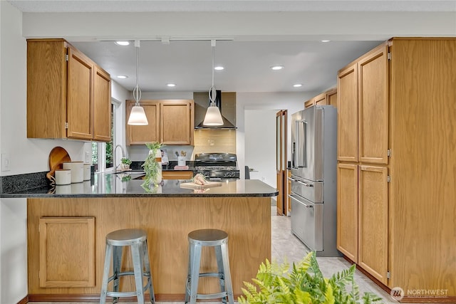 kitchen with high quality fridge, black range with gas cooktop, a peninsula, wall chimney exhaust hood, and recessed lighting