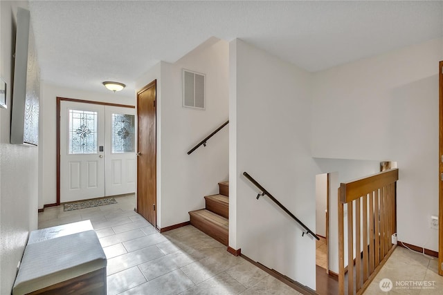 foyer entrance featuring baseboards and light tile patterned floors