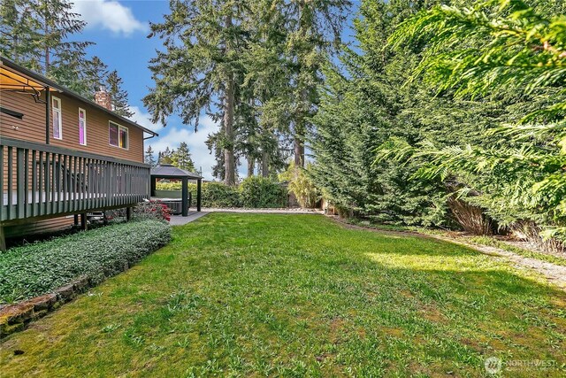 view of grassy yard featuring a gazebo and a deck