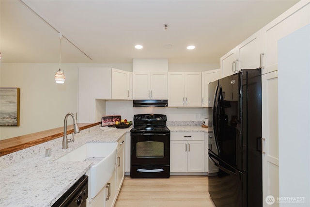 1750 152nd Ave NE Unit W110, Bellevue, WA 98007 - kitchen featuring black appliances, under cabinet range hood, white cabinetry, a sink, and light stone countertops