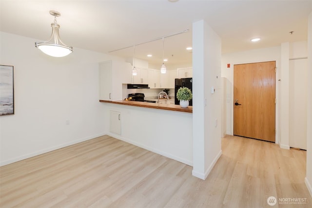 1750 152nd Ave NE Unit W110, Bellevue, WA 98007 - kitchen with black appliances, light wood-style floors, extractor fan, recessed lighting, and white cabinetry