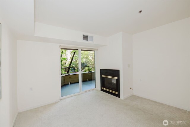 1750 152nd Ave NE Unit W110, Bellevue, WA 98007 - unfurnished living room featuring a glass covered fireplace, light carpet, and baseboards