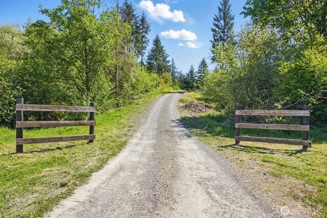 view of dirt / gravel road featuring a wooded view