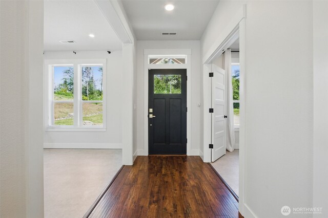 entryway with wood finished floors, baseboards, and recessed lighting