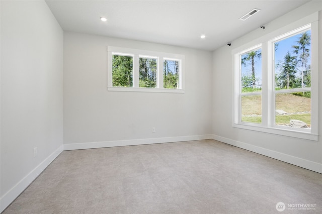 spare room with healthy amount of natural light, baseboards, and recessed lighting