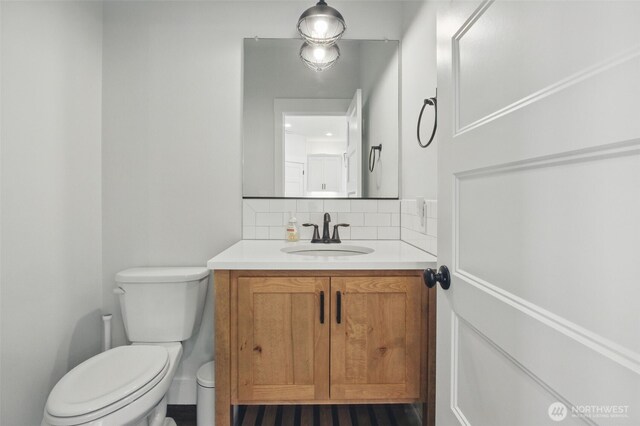 bathroom featuring backsplash, vanity, and toilet
