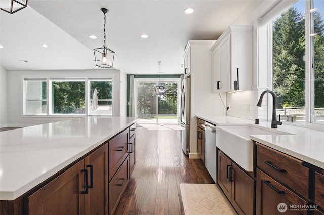 kitchen with stainless steel appliances, a sink, recessed lighting, light countertops, and white cabinets