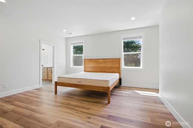 bedroom with light wood finished floors, baseboards, recessed lighting, and connected bathroom