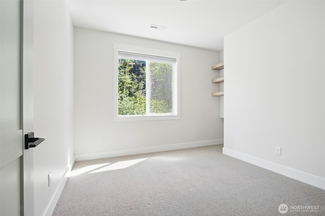 unfurnished room with carpet and baseboards