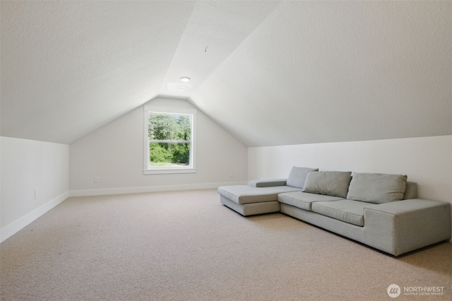 living area featuring light colored carpet, vaulted ceiling, and baseboards