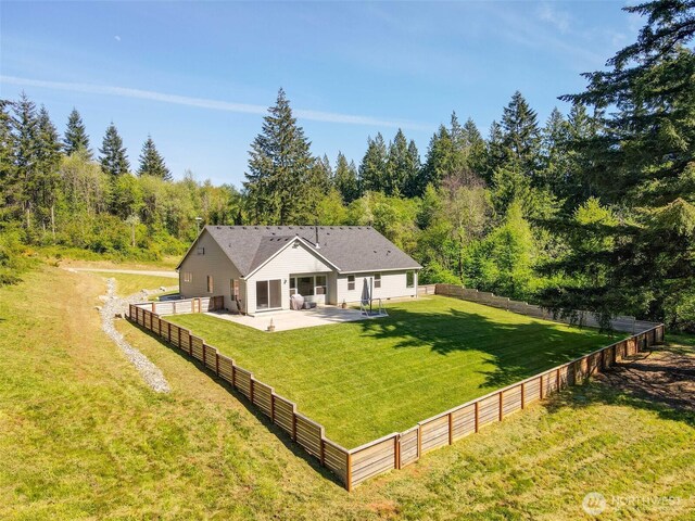 rear view of house featuring a patio and a view of trees