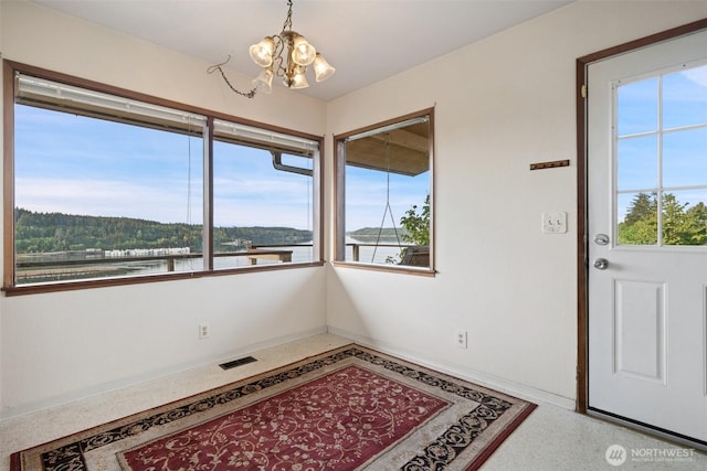 1038 Fairmount Ave, Shelton, WA 98584 - unfurnished dining area with a chandelier, a water view, speckled floor, and baseboards