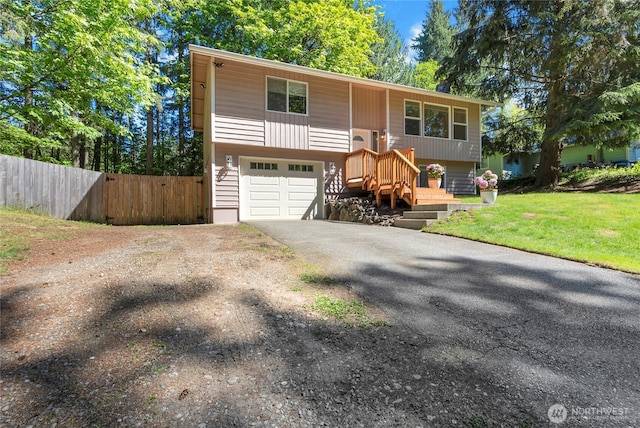 raised ranch featuring asphalt driveway and an attached garage
